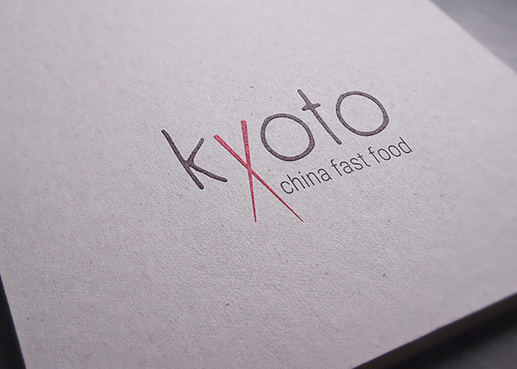 Logo Kyoto china fast food vytištěné na recyklovaném papíře, písmeno X tvoří překřížené hůlky